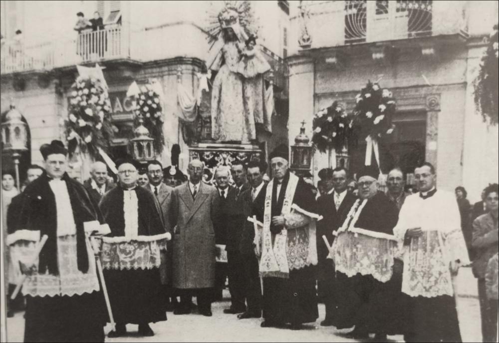 <div class="ql-editor"><div>Processione Odegitria 1954. Riconoscibili Mons. Alberga C., don Giusti D., Mons. Masellis A., don Loconte M., don Vincentis A. ; angolo Via N. Balenzano con Via Settembrini, in secondo piano ex farmacia Guarnieri C. </div><div><br></div><div>La Festa Patronale di Bitritto in onore di <strong>Santa Maria di Costantinopoli</strong> è l’evento più importante per la comunità e affonda le sue radici nel XVI secolo, dopo la pestilenza del 1528-29, quando i cittadini fecero voto alla Madonna promettendo la costruzione di una chiesa in suo onore.</div><div>Nel 1656, durante un’altra epidemia, il paese fu risparmiato e l’evento fu considerato miracoloso, rafforzando ulteriormente la devozione. Da allora la festa si ...