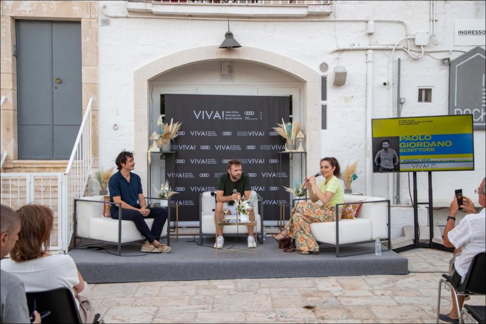 Nella fotografia una scena del dibattito “OSSIGENO, PER TORNARE A RESPIRARE”.
Ospite del primo talk di Extra Viva! (1° agosto 2021) è stato Paolo Giordano, scrittore, editorialista per il Corriere della Sera e vincitore del premio Strega nel 2008. Molteplici i suoi interventi pubblici e preziose le sue lucide riflessioni su ciò che è accaduto nel mondo nel periodo pandemico.
Accanto a Paolo Giordano sono intervenuti la giornalista Simonetta Sciandivasci e il conduttore radiofonico (Rai Radio2) Carlo Pastore.
Le serate all’insegna della musica sono state intervallate dagli appuntamenti dedicati alla convivialità di EXTRA VIVA! 2021, spin off di VIVA! Festival.
EXTRA VIVA! 2021 è un format di incontri, speech e dibattiti in cui dialogano soggetti diversi che guardano insi...