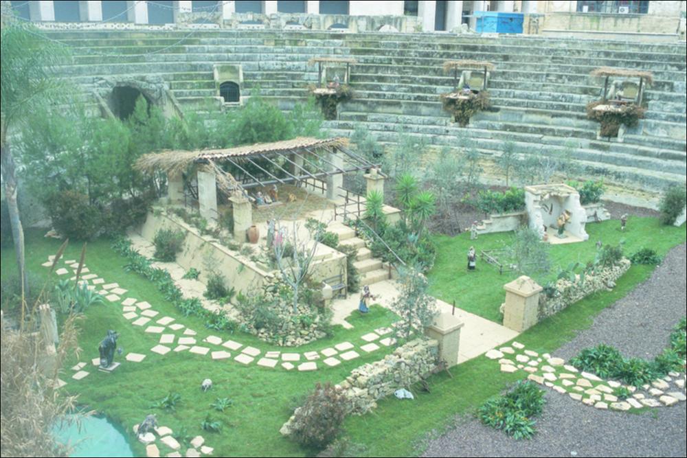 La fotografia è parte della ricca raccolta fotografica “Puglia per tutte le Stagioni” vol. 2, prodotta dall'Assessorato al Turismo e Industria Alberghiera della Regione Puglia, per raccontare la Puglia attraverso immagini suddivise in 5 settori principali: Città e Paesi, Settimana Santa, Territorio, Feste – Sagre – Tradizioni, Mercati – Prodotti – Cucina. L'immagine raffigura il monumentale Presepe che si allestisce ogni anno al centro dell'antico Anfiteatro Romano di Lecce, uno dei simboli della tradizione natalizia locale nel cuore della città pugliese che si inserisce negli itinerari dei presepi, viventi e non, visitabili nel Salento. Vera e propria opera d'arte sacra, il Presepe unisce gli aspetti più tipici della iconografia cristiana agli elementi del territorio p...