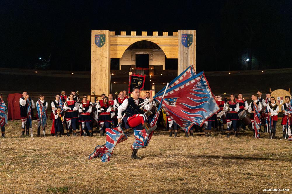 <div>Gli <strong>Sbandieratori e Musici Città di Lucera</strong> sono una compagnia storica attiva nella città, profondamente radicata nella tradizione della rievocazione medioevale e parte integrante delle celebrazioni culturali locali. Il gruppo si esibisce <span>nel suggestivo scenario dell’</span><strong>Anfiteatro Augusteo. </strong><span>La compagnia è </span>composta da oltre 80 iscritti unendo la pratica sportiva e folkloristica dello sbandieramento, delle chiarine e dei tamburi alla diffusione e valorizzazione delle tradizioni storiche di Lucera. Partecipa con continuità alle principali manifestazioni cittadine, tra cui la Settimana Medioevale e il Corteo Storico, sfilando in abiti storici ed esibendosi durante il Torneo delle Chiavi, ...