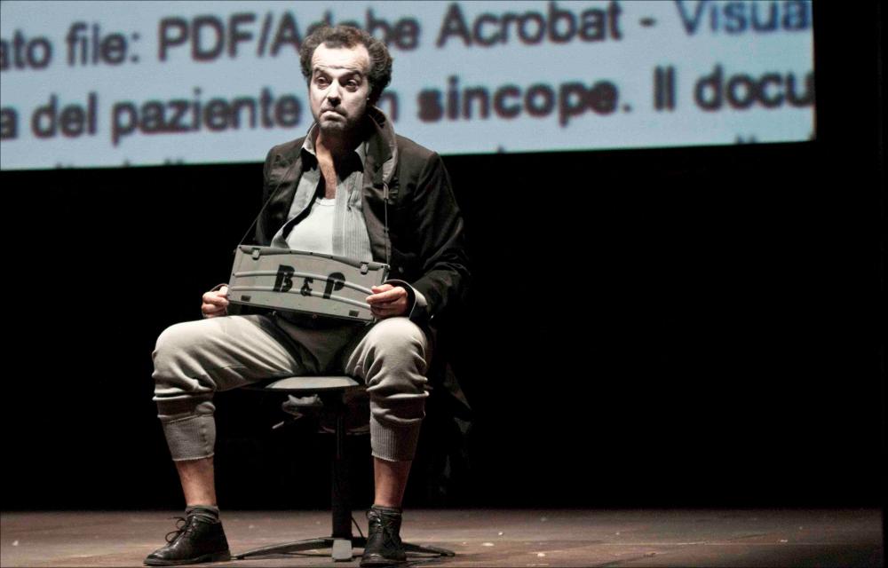 L'immagine digitale è parte della collezione digitale “Prime nazionali in Puglia”, nata dall'omonimo progetto promosso dalla Regione Puglia, Assessorato al Mediterraneo, Cultura e Turismo, finanziato dal FESR ASSE IV e attuato dal Teatro Pubblico Pugliese per dar vita ad un fitto calendario di prime nazionali programmate tra il 2011 e il 2012 all'interno di alcuni teatri pugliesi. La fotografia documenta un istante dell'opera teatrale “Atto finale – Flaubert”, scritta e diretta dal regista salentino Mario Perrotta e andata in scena per la prima volta ad Andria, il 4 settembre 2011, in occasione del Festival Internazionale Castel dei Mondi. Per l'evento il regista scrive il terzo spettacolo di una trilogia dedicata all'uomo e al suo rapporto con la società attuale. Parte...