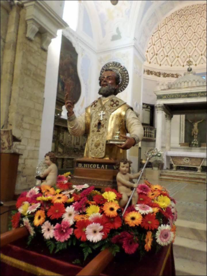 <div class="ql-editor"><div>La foto ritrae <strong>il busto votivo di San Nicola custodito nella Chiesa Matrice di Santa Maria della Colonna e San Nicola</strong>, principale luogo di culto della città di Rutigliano. </div><div><br></div><div>La <strong>Festa Patronale di Rutigliano</strong> è dedicata a San Nicola e affonda le sue radici nel <strong>1306</strong>, quando Carlo II d’Angiò donò la città al Capitolo della Basilica di San Nicola di Bari, sancendo così il patronato del Santo sulla comunità rutiglianese. I festeggiamenti religiosi e civili si svolgono <strong>nel secondo fine settimana di maggio</strong> e sono preceduti dal <strong>Corteo Storico di San Nicola</strong>, rievocazione nata nel 2007 che ricorda l’...