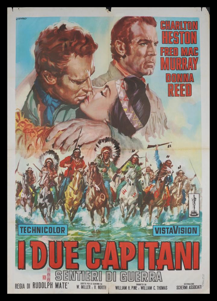 L'immagine riproduce uno dei manifesti conservati presso la Mediateca Regionale Pugliese (vedi Note). Si tratta di una delle versioni grafiche del manifesto del film "I due capitani (Sentieri di guerra)", a firma di Renato Casaro, tra i maggiori rappresentanti della grafica e del manifesto del secondo dopoguerra. Autodidatta, sviluppa una grande tecnica e raffinatezza formale sugli esempi più prestigiosi di altri pittori di cinema, primo tra tutti Cesselon, alla quale mescola linguaggi compositivi più innovativi (fotografico e grafico) anche usando tecniche e strumenti diversi, come l'aerografo. Per il manifesto in oggetto, Casaro realizza una composizione di grande impatto scenografico, anche grazie all'uso di una gran varietà di colori brillanti. Il celeste netto dell...