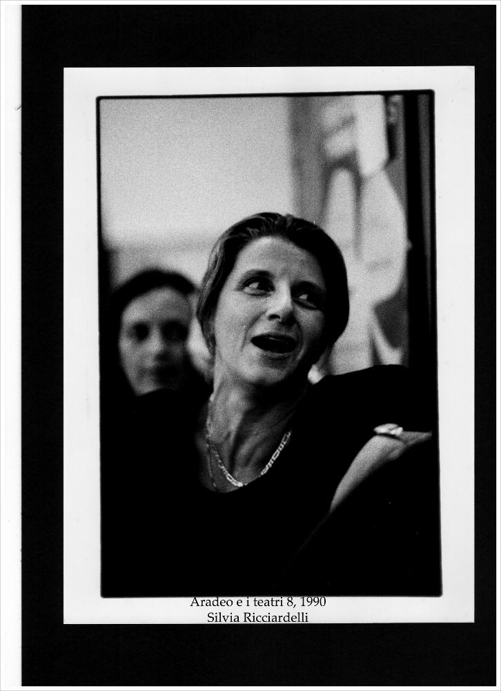 La fotografia in bianco e nero è un bel ritratto dell'attrice di teatro italiana Silvia Ricciardelli, ospite della rassegna annuale “Aradeo e i Teatri”, un appuntamento con il teatro sperimentale che la compagnia Koreja nata nel 1983 nel piccolo borgo salentino di Aradeo porta avanti sin dall'anno della sua fondazione. Nel 1990, durante l'ottava edizione della più importante kermesse culturale e teatrale della Puglia dell'epoca, la Ricciardelli operò in "Canti in silenzio", una sezione del festival dedicata al lavoro sulla voce. Il seminario svoltosi presso il Castello "Tre masserie", la sede di Koreja, si svolse dal 29 luglio al 3 agosto con spettacoli in forma di concerto diretti da Julia Varley, con la partecipazione di Helen Chadwick, Brigitte Cirla, Ida Keravola, S...