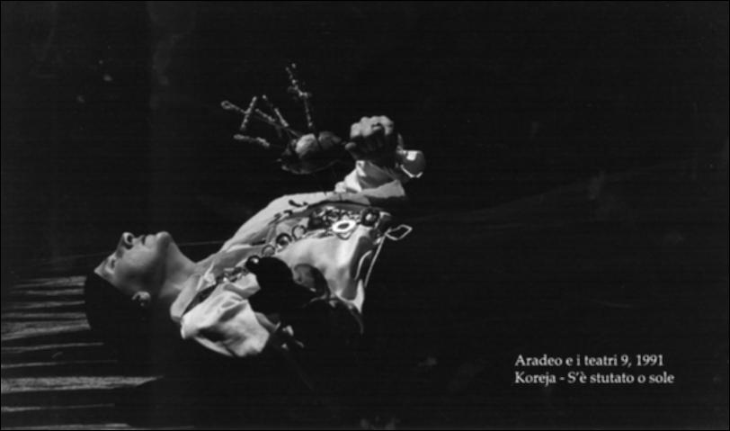 La fotografia in bianco e nero cattura un momento dello spettacolo "S'è stutato o' sole", messo in scena nel 1991 dalla compagnia Koreja, nata nel 1983 nel piccolo borgo salentino di Aradeo, dove ha dato vita anche al prestigioso festival annuale "Aradeo e i Teatri", avviato nell'anno della loro fondazione. La pièce, diretta dal regista del gruppo Salvatore Tramacere, racconta di un Sud nel quale viene emanato un editto che vieta alle donne di avere figli. Da qui, nasce il tragicomico percorso di una madre, suddiviso in quattro movimenti che rappresentano quattro diversi stati d'animo, all'inseguimento di un figlio, insieme ad un'altra donna, non madre. Con lo spettacolo, Koreja dà vita ad una "farsa tragica" nella quale le donne affrontano situazioni vere e crude e i f...
