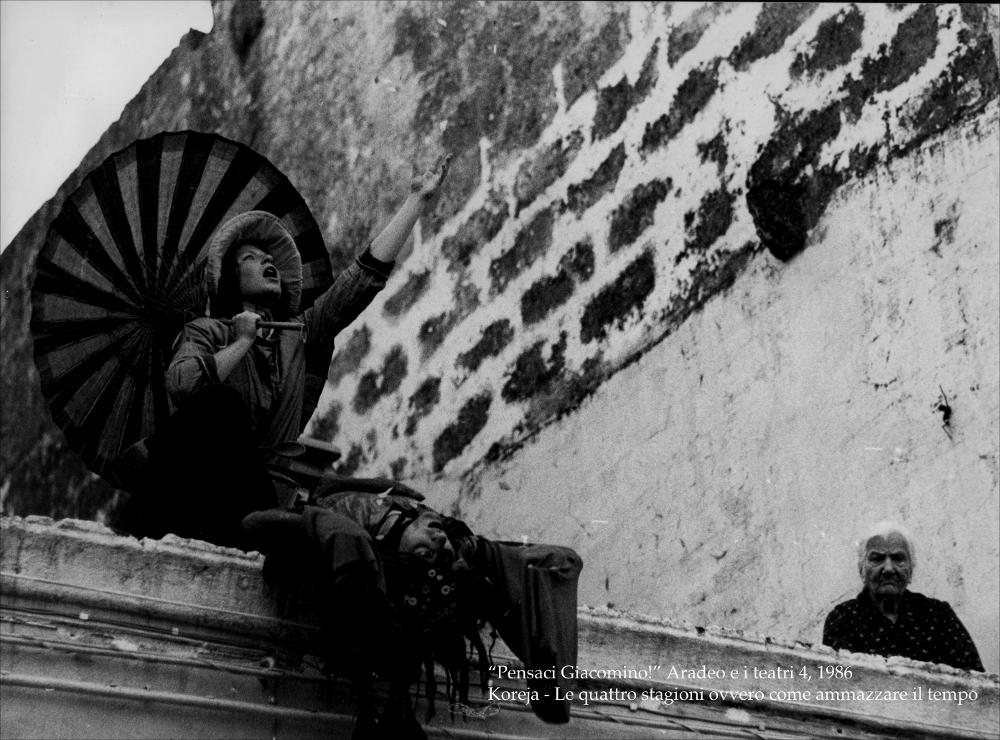 La fotografia in bianco e nero cattura uno dei momenti della performance “Quattro stagioni - Ovvero come ammazzare il tempo”, messa in scena nel 1986 nell'ambito della rassegna “Aradeo e i Teatri” (4) inaugurata in quell'anno con il titolo “Pensaci Giacomino! Omaggio a Pirandello” per il cinquantenario della morte dello scrittore. La rassegna divenne un vero e proprio appuntamento con il teatro sperimentale che la compagnia nata nel 1983 nel piccolo borgo salentino di Aradeo portò avanti sin dall'anno della sua fondazione. Lo spettacolo è il frutto di otto mesi di ininterrotto lavoro non solo individuale, dei singoli artisti coinvolti, ma soprattutto collettivo. “Quattro stagioni” è una rappresentazione itinerante, si muove per le strade di Aradeo in quattro quadri-azio...