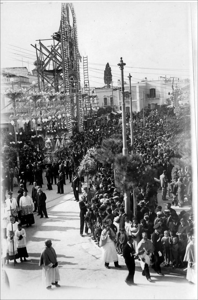 <div>Lo scatto fotografico, risalente al 1930, immortala il rito della processione in cammino durante la Festa Patronale di San Michele Arcangelo. La ricorrenza, istituita proprio nel 1930, si celebra annualmente la quarta domenica di ottobre a Carbonara di Bari e ha come momento più solenne la processione del Santo.</div><div>Oggi la manifestazione prevede l’allestimento di luminarie a LED a basso consumo energetico, mentre i fuochi pirotecnici non vengono più realizzati. Il fulcro delle celebrazioni religiose è rappresentato dalla processione solenne della domenica, affiancata dalla processione del quadro il sabato e da quella della statua il lunedì.</div><div>Accanto agli eventi religiosi, si svolgono anche diverse iniziative civili: tre spe...