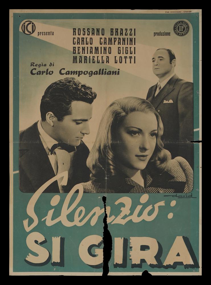 L'immagine riproduce uno dei manifesti conservati presso la Mediateca Regionale Pugliese (vedi Note). Si tratta di una delle versioni grafiche delle fotobuste del film "Silenzio: si gira!" del 1943 per la regia di Carlo Campogalliani. A firma di David la composizione della fotobusta è molto semplice e pulita, in bianco e nero come il film, vi sono solo i tre attori principali: il giovane Andrea Corsi e la bella Eva in primo piano, mentre il tenore Massimo Giuliani si erge alle loro spalle....