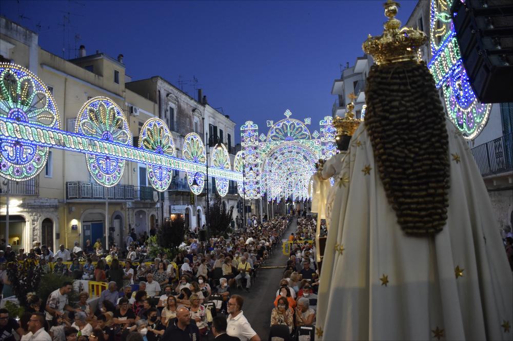 <div class="ql-editor"><div> Lo scatto fotografico del 2022 ritrae un momento della Messa solenne celebrata il 16 luglio in onore della Madonna del Carmine, Patrona di Noicattaro. In questo giorno di festa, una folla numerosa si raccoglie per vivere insieme un’intensa esperienza di fede e devozione, immersa tra le luminarie colorate e animata da un profondo senso di appartenenza alla comunità.</div><div>La festa patronale di Santa Maria del Carmine a Noicattaro, celebrata ogni anno il 16 luglio e nel fine settimana successivo, rappresenta uno degli appuntamenti più significativi per la comunità, sia dal punto di vista religioso sia culturale. È un momento di intensa partecipazione collettiva, che unisce devozione, tradizione e vita sociale.</di...