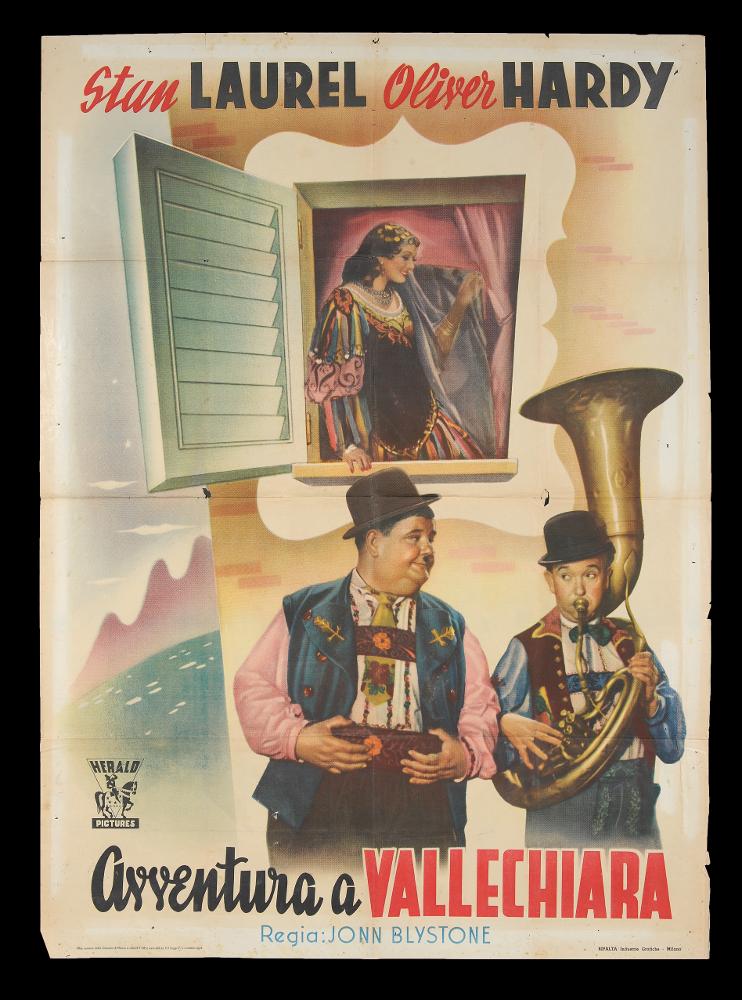 L'immagine riproduce uno dei manifesti conservati presso la Mediateca Regionale Pugliese (vedi Note). Si tratta di una delle versioni della locandina del film "Avventura a Vallechiara", una delle moltissime composizioni grafiche realizzate per la comicità di Stanlio & Ollio, il duo iconico tra i più amati della storia del cinema. Dei due protagonisti, viene messo in risalto proprio il loro stile unico e caratterizzante, fondato su una comicità elementare che sfrutta la mimica facciale e il linguaggio del corpo per gag semplici ed esilaranti, adatte a ogni tipo di pubblico. I due attori, qui ripresi con molta probabilità da fotografie di scena, risaltano dai colori pastello, molto chiari, che caratterizzano l'opera grafica in oggetto....