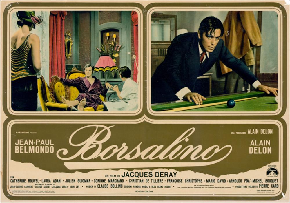 L'immagine digitale in oggetto è scansione della fotobusta originale del film "Borsalino", elaborata in occasione della mostra "Riccardo Cucciolla - Ritratto d'Attore" organizzata nel 2012 dall'Associazione culturale “Attraverso lo Spettacolo”, dall'Assessorato al Mediterraneo, Cultura e Turismo della Regione Puglia e dal Servizio Biblioteca e Comunicazione Istituzionale del Consiglio Regionale della Puglia. L'opera, dai toni caldi e raffinati, è divisa in tre riquadri: due superiori che includono scene tratte dal film e una inferiore che mette insieme il titolo e i nomi degli attori. Il film, diretto da Jacques Deray e prodotto da Alain Delon, esce nelle sale italiane nel 1970. Tratta dal romanzo francese “Bandits à Marseille” di Eugène Saccomanno, la pellicola, ambien...