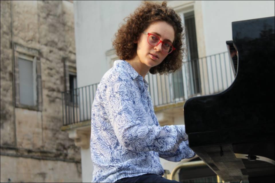 L'immagine è parte della manifestazione Time Zones edizione 2018, un calendario fitto e intenso di spettacoli programmati tra settembre e novembre. La fotografia è un primo piano della pianista italiana Daniela Mastrandrea. Diplomata al Conservatorio "Nino Rota" di Monopoli, ha da sempre composto musica, vincendo numerosi premi. La fotografia in oggetto documenta uno dei momenti del concerto tenuto dalla pianista, ovvero l'opening all'artista Baby Dee nell'Auditorium Vallisa di Bari....