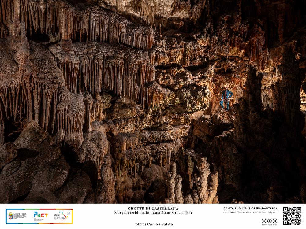 Una gigantesca parete riccamente decorata da cascate di concrezioni stalagmitiche.
In questa caverna la roccia ha assunto le forme più bizzarre, concrezioni sottili e appuntite, altre piene e bitorzolute, altre ancora levigate e possenti.
L’immagine digitale fa parte della raccolta di fotografie prodotte da Carlos Solito per il Progetto digitale “Sillabario sotterraneo – Viaggio dantesco nelle Grotte di Puglia” – realizzato nell’ambito della LEGGE REGIONALE 30 dicembre 2020, n. 35 - art. 39 “Cavità pugliesi e opera dantesca - Celebrazioni 700 anni dalla morte di Dante Alighieri”.