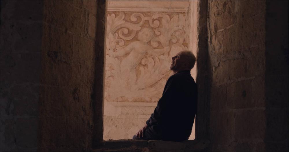 Lo scatto ritrae l’attore Luigi Mezzanotte in una scena tratta dal cortometraggio “Il Misuratore del Mondo”, opera della regista Irene Gianeselli, girato presso la Masseria Jesce di Altamura (2021). Con questo cortometraggio, la giovane regista pugliese Irene Gianeselli ci fa entrare in una nuova dimensione kafkiana, segnata dalle atmosfere mediterranee e rurali della masseria Jesce di Altamura che accoglie una struttura narrativa e interpretativa originale e nettamente ispirata al teatro. Il risultato è un’opera piena di spunti interessanti che è valso, alla Gianeselli e alla sua troupe, l’ingresso nella selezione ufficiale del David di Donatello 2022. Il monologo è liberamente tratto da “Il castello” di Franz Kafka e Luigi Mezzanotte n’è l’attore protagonista, raccogl...
