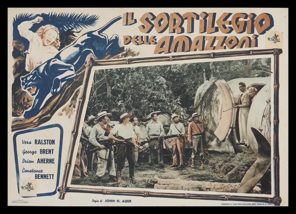L'immagine riproduce una delle opere grafiche conservate presso la Mediateca Regionale Pugliese (vedi Note). Si tratta nello specifico di uno dei soggetti della fotobusta del film “Il sortilegio delle Amazzoni” del 1948 per la regia di John H. Auer. La bella composizione, come di consueto per le fotobuste, al centro presenta una fotografia di scena, con una cornice di bambù attorno che la evidenzia. Sulla sinistra, l'illustrazione dell'artista Guerri presenta una scena del film con alcuni elementi naturali che fanno percepire l'ambientazione esotica della giungla, in cui domina la figura della pantera. Armonica e fuori dal comune la scelta dei colori a contrasto....