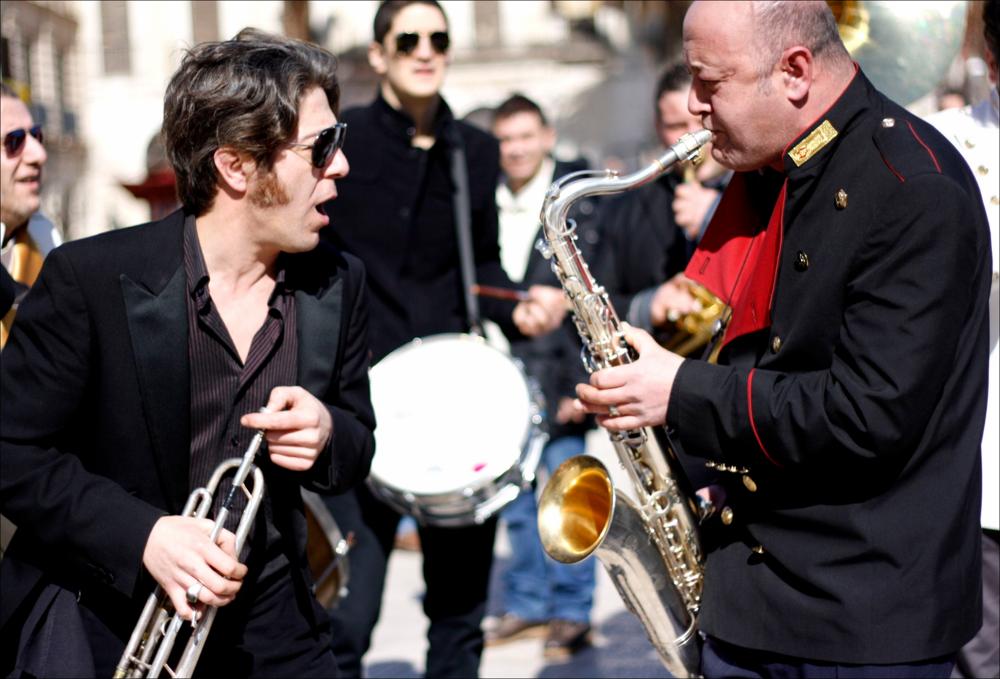 L'immagine fa parte di “Primavera dei Diritti", collezione digitale che raccoglie foto e video dell'omonima manifestazione promossa dalla Regione Puglia - Assessorato al Mediterraneo e realizzata dal Teatro Pubblico Pugliese dal 18 al 28 febbraio 2010 a Bari. La fotografia luce ambiente immortala un momento della performance "La Fanfara di GirodiBanda”, nucleo del progetto dell'etichetta discografica indipendente leccese 11/8 Records, composto da alcuni membri di una banda “da giro” pugliese e del gruppo multietnico degli Opa Cupa. Gli arrangiamenti del repertorio, eseguiti e curati da Cesare Dell'Anna, già bandista da generazioni e leader del gruppo fondato nel 1997, sono eseguiti con l'intento di attualizzare la musica popolare intesa in senso stretto, passando dalla ...