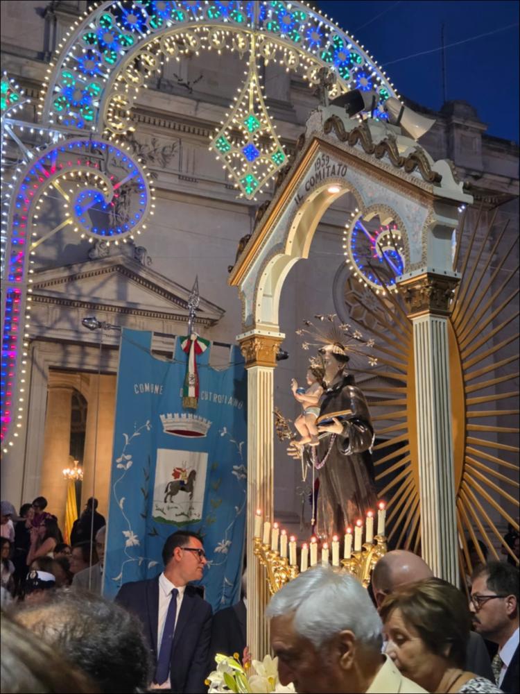 <div class="ql-editor"><div>Lo scatto fotografico riprende la Statua di Sant’Antonio di Padova mentre esce dalla Chiesa di Santa Maria delle Neve di Cutrofiano (LE) durante i festeggiamenti in onore del Santo Patrono.</div><div>I festeggiamenti consistono in tre giorni di festa preparati da una tradizionale tredicina. La vigilia (12 giugno) è la giornata nella quale si accendono le luminarie nel centro storico; il servizio bandistico anima le strade della città; la messa solenne concelebrata dai sacerdoti delle due parrocchie e i ministri; la grande processione e la consegna delle chiavi della città al Santo da parte del sindaco; la festa con le baracche e l’animazione musicale/bandistica; le giostre per i bambini e i ragazzi.</div><div>Il 13,...