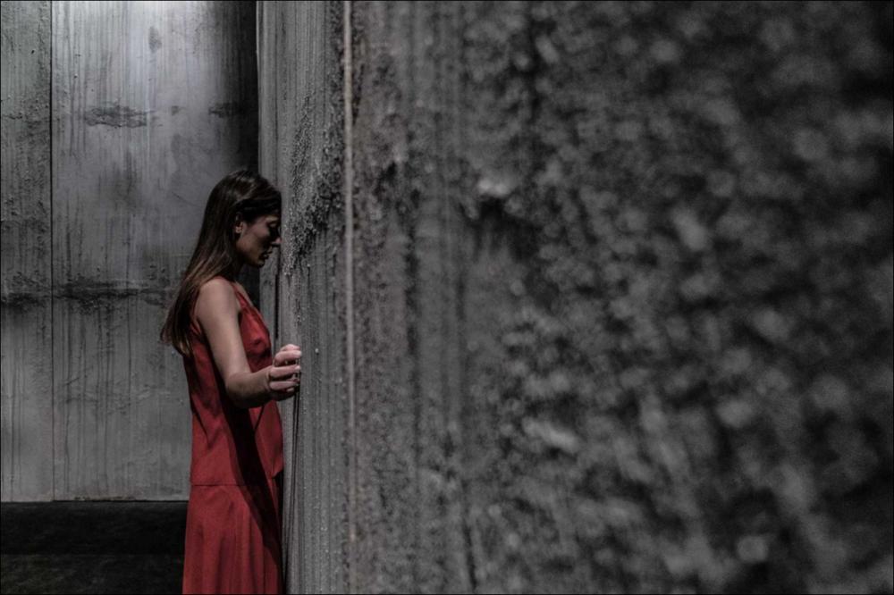 La fotografia in oggetto, ad opera di Alessandro Serra, immortala un momento dello spettacolo “Frame”, spettacolo messo in scena dalla compagnia teatrale Koreja di Lecce con la co-produzione della Compagnia Teatropersona. Frame è uno spettacolo che abbraccia arte e teatro, ispirato nelle scene alle opere dell'artista statunitense Edward Hopper. Una vera e propria immersione nel mondo e nelle opere dell'artista attraverso la descrizione di momenti, persone e frammenti che scandiscono la vita quotidiana dell'uomo contemporaneo. Non ci sono voci ad animare la scena, ma luci, suoni, abiti che riescono a coinvolgere lo spettatore, rendendo lo spettacolo simile ad una visita museale e lo spettatore diviene fruitore che insieme vive e crea l'opera. In questa fotografia, l'attr...
