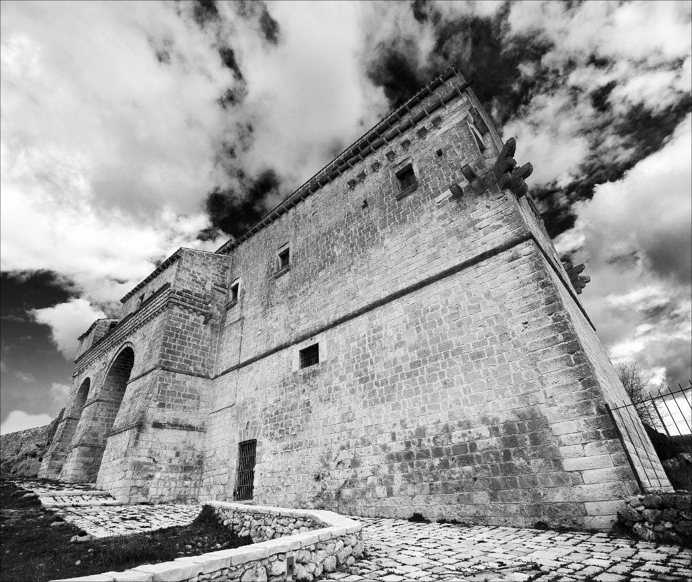 La fotografia fa parte di una più ampia raccolta di fotografie realizzate per il progetto di censimento di 248 masserie pugliesi avviato da Giancarlo Chielli, professore del corso in Beni Culturali e Ambientali presso l'Accademia di Belle Arti di Bari. Il lavoro svolto ha dato vita al volume “Le masserie di Puglia come Bene Culturale” in cui sono presenti alcuni scatti di masserie pugliesi tra cui quella in oggetto. L'immagine è un'affascinante ripresa dal basso del prospetto laterale di Masseria Jesce, generata in bianco e nero e successivamente post prodotta. L'opera evidenzia la linearità di forme e la chiarezza strutturale tipica delle costruzioni pugliesi di questo tipo, per la maggior parte edificate usando il tufo delle cave, modellato in blocchi parallelepipedi,...