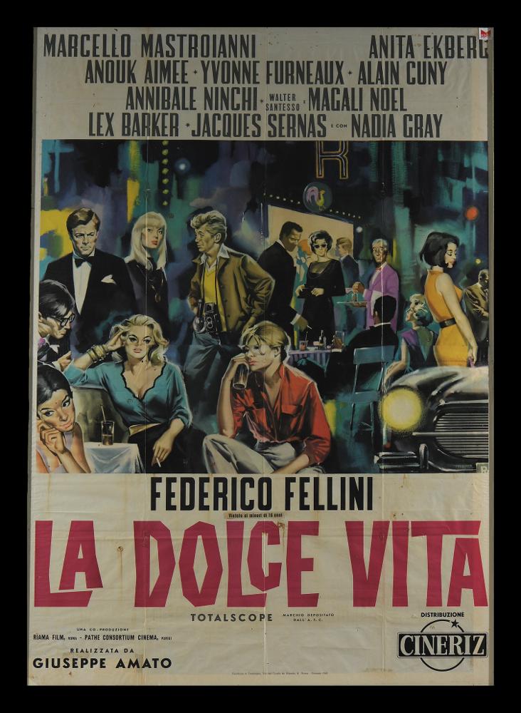 L'immagine riproduce uno dei manifesti conservati presso la Mediateca Regionale Pugliese (vedi Note). Si tratta di una delle versioni grafiche del manifesto de "La dolce vita", uno dei film più famosi del regista Federico Fellini. Anche se senza firma, ci troviamo di fronte ad un'opera pittorica narrativa, ricca di dettagli e ritratti di personaggi, che diventano simboli di una Roma apparentemente sana e felice, ma che in realtà cela una profonda crisi dei costumi borghesi e dell'uomo. La scena corale è raffigurata di sera: i colori sono freddi, illuminati dalle luci dei neon di locali e vetrine, le pennellate intorno alle figure sono sfumate, tutto sembra fermo in una velata malinconia e tristezza. Splendidi e riconoscibili gli attori, primo tra tutti Marcello Mastroia...