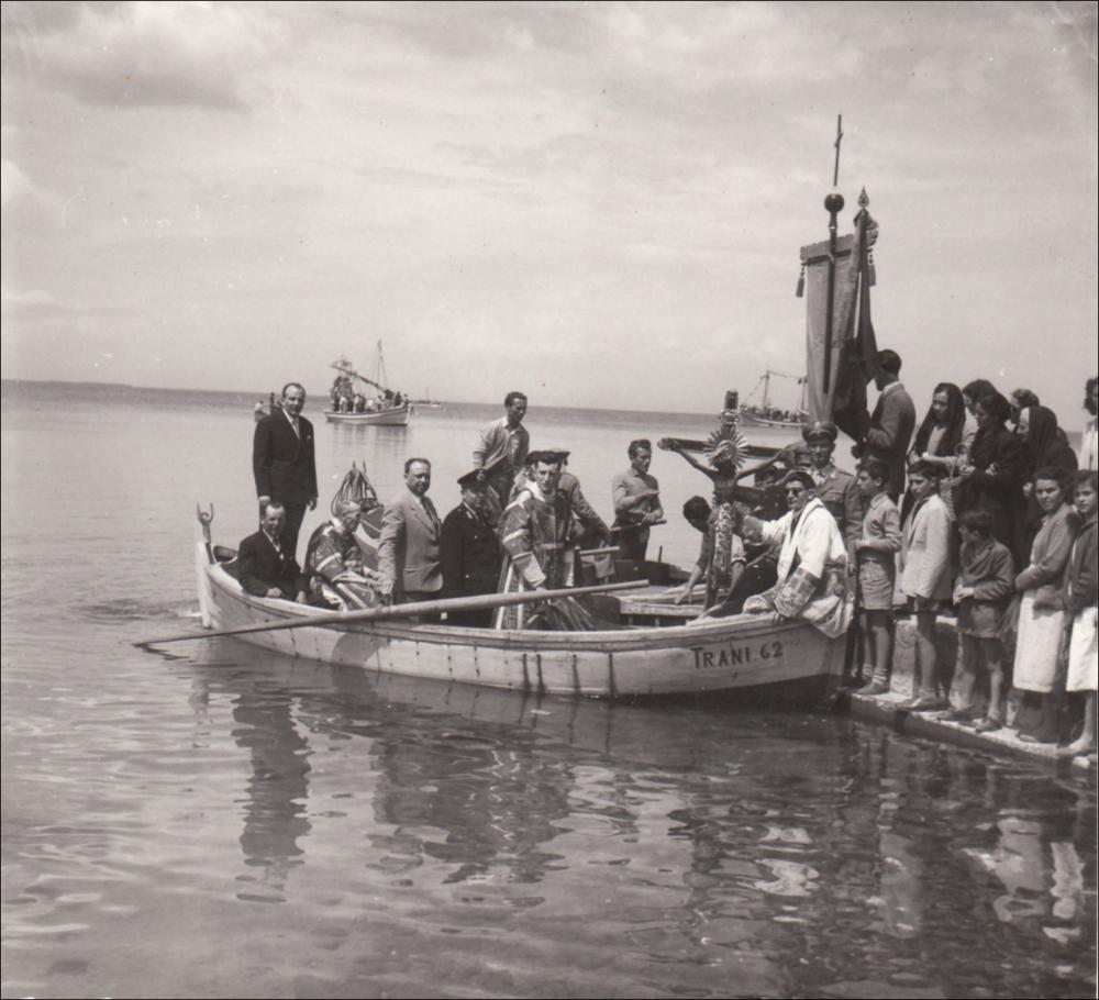 <div class="ql-editor"><div>Questa foto storica digitalizzata, databile agli anni '60, immortala un momento simbolico della Festa Patronale del Santissimo Crocifisso di Colonna a Trani, ovvero il trasporto via mare del Crocifisso. Questo festeggiamento rappresenta uno degli appuntamenti religiosi e civili più sentiti dalla comunità di Trani (BT), espressione profonda della fede e dell’identità cittadina.</div><div>Fulcro della celebrazione è il venerato Crocifisso ligneo custodito nel Santuario di Colonna, legato a un prodigio risalente al 1480, epoca dell’invasione turca in terra d’Otranto e del martirio degli Ottocento Cristiani. Secondo la tradizione, il Crocifisso, trafugato da pirati saraceni, venne sfregiato sul volto e gettat...