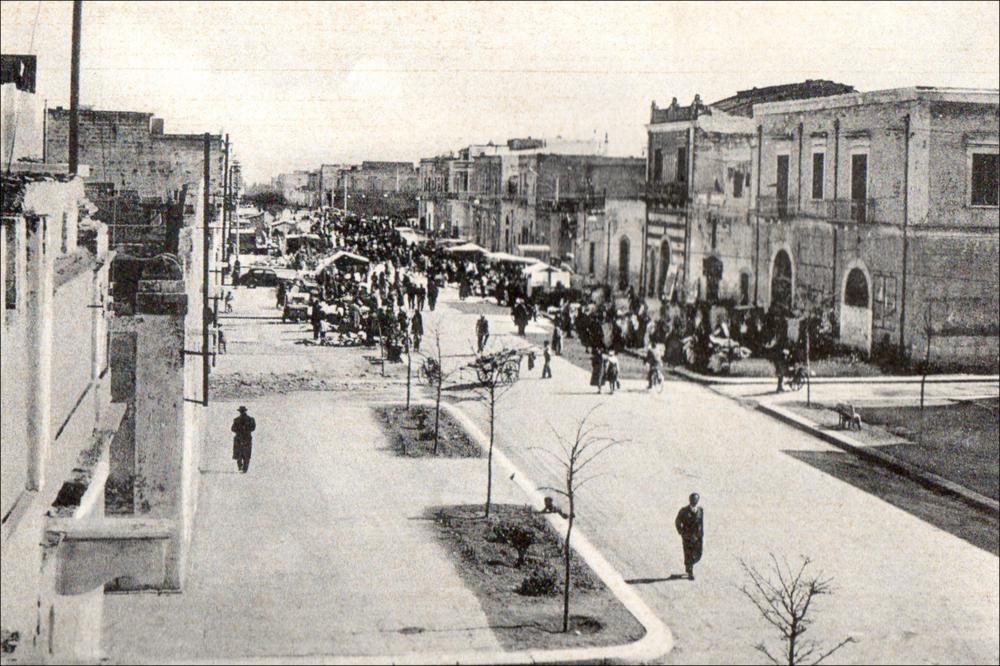<div class="ql-editor"><div>La fotografia storica, di anno non definito ma probabilmente risalente agli anni Trenta o Quaranta del Novecento, ritrae il corso principale della città di <strong>San Ferdinando di Puglia</strong> durante i giorni della festa patronale dedicata a San Ferdinando Re.</div><div>Lungo la strada si distinguono gli stand e le bancarelle allestite per l’occasione, segno dell’atmosfera festiva che animava il centro cittadino. L’immagine offre uno spaccato della vita del paese in quel periodo, permettendo di coglierne l’aspetto urbanistico e l’organizzazione degli spazi pubblici durante la celebrazione.</div><div><br></div><div>La <strong>festa patronale di San Ferdinando Re</strong> è la principale celebrazion...