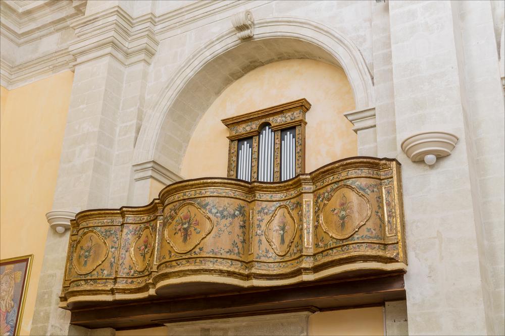L'organo rappresentato nell'immagine digitale è collocato nella chiesa di S. Maria delle Grazie di Vaste. La chiesa è stata edificata nel 1761 dal barone Ippazio De Marco, come ricorda una iscrizione sul portale. L’interno ad aula unica presenta altari settecenteschi dedicati a S. Gaetano, Madonna delle Grazie e Madonna del Carmine. L’organo è nella cantoria collocata nell’ultimo arcone sul presbiterio. Pregevole l’andamento curvilineo in un sottile gioco concavo/convesso con al centro medaglioni in cui sono raffigurati delicati motivi floreali su un fondo giallino che vorrebbe simulare l’oro. La cassa d’organo è molto semplice, presenta nel prospetto tre campate suddivise da pilastri e una ricca decorazione floreale dipinta che richiama i motivi della cantoria. Carlo M...