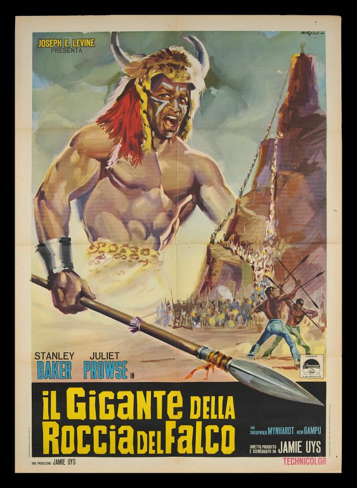 L'immagine riproduce uno dei manifesti conservati presso la Mediateca Regionale Pugliese (vedi Note). Si tratta di uno dei manifesti del film “Il gigante della roccia del falco” del 1965 per la regia di Jamie Uys. La firma che si legge in alto a destra è dell’illustratore Serafini, molto attivo tra gli anni Sessanta e gli anni Settanta. Protagonista indiscusso della composizione è l’indigeno interpretato da Ken Gampu, immortalato in abiti da combattimento, copricapo con pelliccia e corna di animale, viso segnato per la battaglia, mentre impugna una lancia che sembra oltrepassare il foglio. Il guerriero sovrasta un cielo nuvoloso e guarda una montagna, probabilmente la roccia del falco menzionata nel titolo, sul quale sale una orda di indigeni non definiti nei lineamenti...
