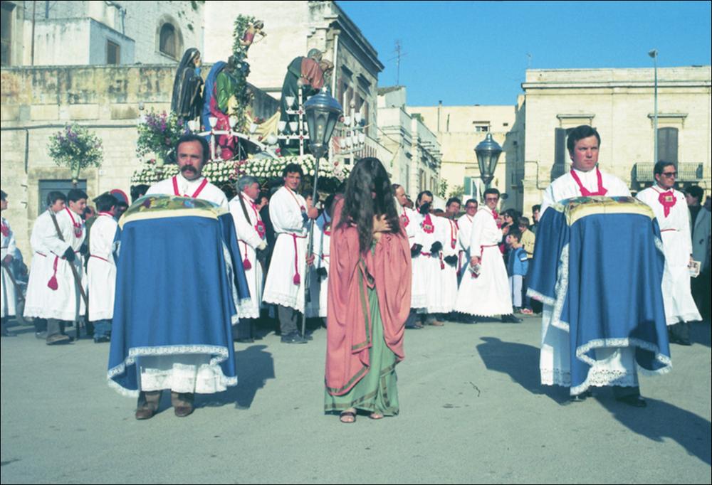 La fotografia è parte della ricca raccolta fotografica “Puglia per tutte le Stagioni” vol. 2, prodotta dall'Assessorato al Turismo e Industria Alberghiera della Regione Puglia e creata per raccontare la Puglia attraverso immagini diverse suddivise in 5 settori principali: Città e Paesi, Settimana Santa, Territorio, Feste – Sagre – Tradizioni, Mercati – Prodotti – Cucina. L'immagine digitale mostra un momento della processione degli “Ottosanti” durante la Settimana Santa a Ruvo di Puglia. Dopo la processione notturna che parte dalla Chiesa di S. Rocco alle 02:00 della notte tra il mercoledì e il giovedì santo, e percorre tutte le vie del paese, la processione in mattinata si ferma verso le ore 09:00. L'imponente gruppo scultoreo in cartapesta, noto come degli "Otto Santi...