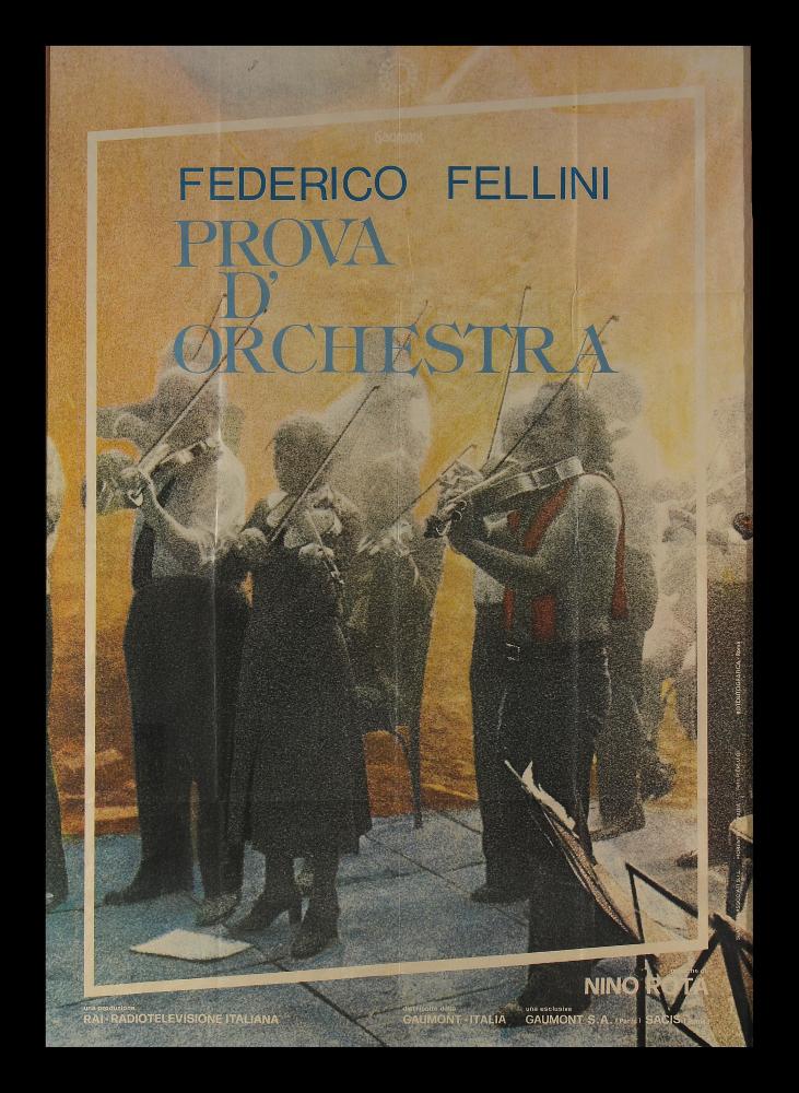 L'immagine riproduce uno dei manifesti conservati presso la Mediateca Regionale Pugliese (vedi Note). Si tratta del manifesto di "Prova d'orchestra", film italiano del 1979 del regista Federico Fellini. La composizione è realizzata tutta intorno ad una fotografia di scena (a firma di "Pierluigi" come si legge sul fianco destro). L'atmosfera è fumosa, impalpabile, la fotografia presenta molto "rumore", un effetto che quasi ricorda quello pittorico del pointillisme francese (o puntinismo) di fine Ottocento. Il risultato è affascinante, magico ed onirico, in puro stile felliniano....