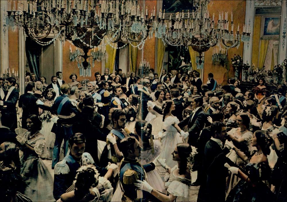 L'immagine digitale è un ritaglio della riproduzione fotografica della fotobusta de “Il Gattopardo” elaborata in occasione della mostra "Cinema 150 anni. Mostra di manifesti cinematografici d'epoca sul Risorgimento", utilizzato per realizzarne cartoline promozionali. La mostra, allestita negli spazi della Mediateca Regionale di Bari, è stata realizzata nel 2011 dall'Ufficio Attività culturali e audiovisivi, afferente al Servizio Cultura e Spettacolo della Regione Puglia, in occasione delle celebrazioni dei 150 anni dell'Unità d'Italia. Il dettaglio scelto ripropone fedelmente nei volti, negli sguardi, nei costumi, nei colori e nella grande sala, l'elegante scena corale del ballo che conclude il film e che, oltre a segnare il cambiamento di un epoca storica, diventerà co...