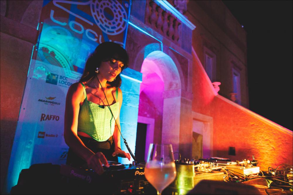 <div>Lo scatto racconta l’energia del dj-set di <strong>Coco Maria</strong>, artista messicana cresciuta tra Londra e Berlino e oggi figura di riferimento della musica latina più vibrante ed effervescente. Il suo set, sospeso tra Caraibi, Centro e Sud America, ha animato la serata dell’11 agosto 2024 presso la Masseria Ferragnano, in occasione della XX edizione del Locus Festival.</div>...