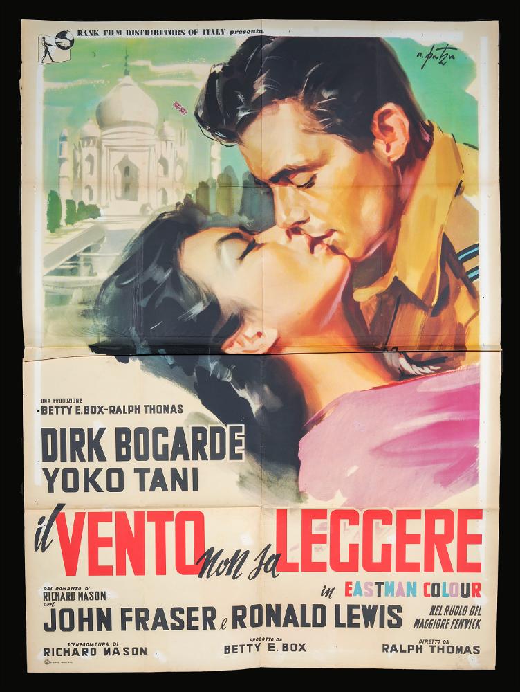 L'immagine riproduce uno dei manifesti conservati presso la Mediateca Regionale Pugliese (vedi Note). Si tratta di una delle versioni grafiche per il manifesto del film "Il vento non sa leggere" del 1958 per la regia di Ralph Thomas a firma dell’illustratore romano Arnaldo Putzu, collaboratore di Enrico De Seta e dello studio Favalli. Lo stile di Putzu è riconoscibile per la drammaticità del suo tratto e della scelta del momento rappresentato, qui un intenso bacio fra i due protagonisti in primo piano, rappresentati con tinte sfumate. Sullo sfondo il mausoleto Taj Mahal, patrimonio dell'umanità dell'UNESCO e inserito nel 2007 fra le nuove sette meraviglie del mondo....