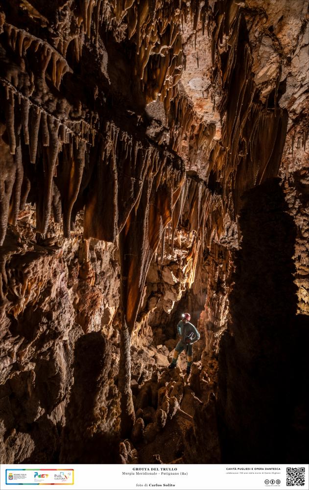 Suggestivo questo scorcio della Grotta del Trullo a Putignano.
Un vero spettacolo naturale si presenta agli occhi del visitatore: la terra ricca di ossidi di ferro e alluminio ha dato vita a pareti costellate da vele di stalattiti e stalagmiti dalle tinte infuocate, che contrastano con il candore delle innumerevoli concrezioni calcaree.
L’immagine digitale fa parte della raccolta di fotografie prodotte da Carlos Solito per il Progetto digitale “Sillabario sotterraneo – Viaggio dantesco nelle Grotte di Puglia” – realizzato nell’ambito della LEGGE REGIONALE 30 dicembre 2020, n. 35 - art. 39 “Cavità pugliesi e opera dantesca - Celebrazioni 700 anni dalla morte di Dante Alighieri”.
