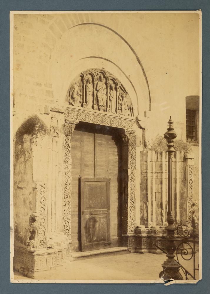 <div class="ql-editor"><div><span>Ritaglio da fotografia di Romualdo Moscioni del portale con iscrizione di Simeon Raguseus (XIII-XIV secolo) della Chiesa di Sant’Andrea a Barletta.</span></div><div><span class="ql-cursor">﻿</span>L'immagine fa parte dell'Archivio fotografico di Giuseppe Ceci.</div><div>La raccolta fotografica di Giuseppe Ceci (1863-1938), studioso delle arti figurative dell’Italia meridionale e tra i promotori delle Società di Storia Patria di Napoli e della Puglia, si inserisce nel vivace clima culturale dell’Italia postunitaria, caratterizzato dal progressivo consolidarsi di una «coscienza nazionale» alimentata anche dal confronto e dal dialogo con le realtà storiche e culturali locali.</div><div>Oggi la B...