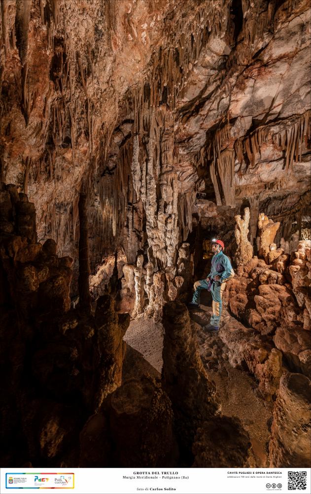Straordinaria veduta interna della Grotta del Trullo a Putignano.
Imponenti concrezioni stalattitiche si elevano dal basso, quasi a voler raggiungere il soffitto della caverna ricco di stalattiti finissime e dalle tinte rossastre per la ricca presenza di ossidi di ferro e alluminio.
L’immagine digitale fa parte della raccolta di fotografie prodotte da Carlos Solito per il Progetto digitale “Sillabario sotterraneo – Viaggio dantesco nelle Grotte di Puglia” – realizzato nell’ambito della LEGGE REGIONALE 30 dicembre 2020, n. 35 - art. 39 “Cavità pugliesi e opera dantesca - Celebrazioni 700 anni dalla morte di Dante Alighieri”.