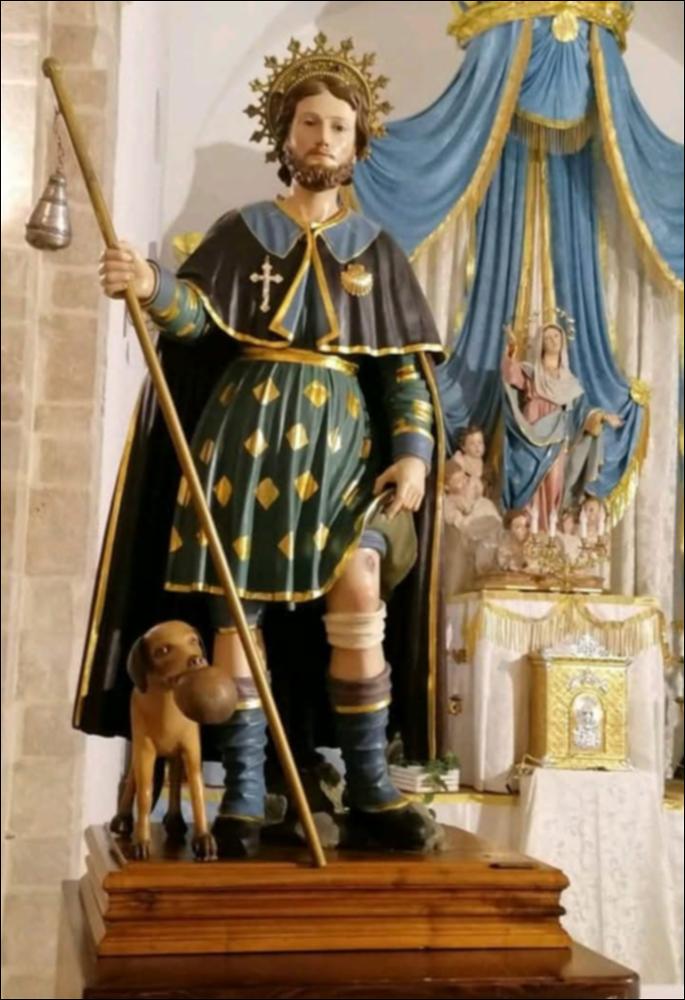 <div class="ql-editor"><div>L’immagine digitale ritrae la statua di San Rocco, Santo Patrono di Rignano Garganico (FG).</div><div>La Festa Patronale in onore di San Rocco, protettore degli appestati, si celebra il 16 agosto ed è preceduta dalla tradizionale novena di preparazione nei giorni antecedenti la solennità.</div><div>Il giorno della festa si svolgono la solenne Celebrazione Eucaristica nell’omonima piazza e la tradizionale processione per le vie del paese, alla quale partecipa una folla numerosa di fedeli, tra cui molti emigranti che rientrano per l’occasione. Il corteo attraversa le suggestive strade del centro storico medievale, creando un’atmosfera di intensa devozione e partecipazione popolare.</div><div>La serata prosegue ...
