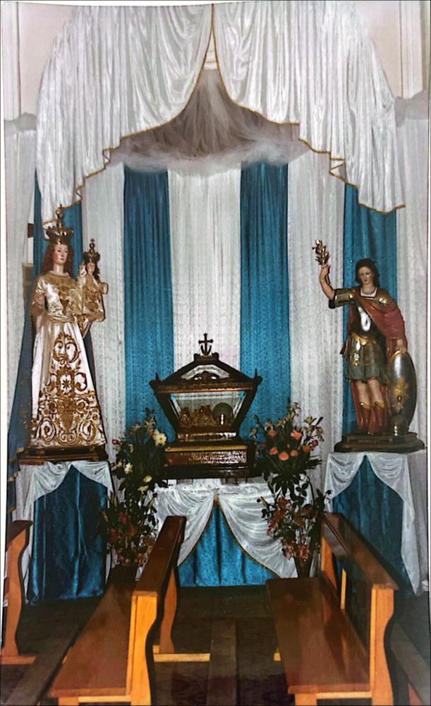 <div class="ql-editor"><div>Fotografia del <strong>1985</strong>: all’interno della chiesa, i simulacri di <strong>San Liberato Martire</strong> e della <strong>Madonna con il Bambino</strong> sono esposti, circondati da drappi bianchi e celesti che richiamano il culto mariano.</div><div><br></div><div>Ogni 19 agosto, San Marco la Catola si ritrova attorno al suo patrono, <strong>San Liberato Martire</strong>, in una festa che unisce tradizione e identità locale. Tra fiera, giochi popolari e sfide cavalleresche, la comunità celebra il ritorno dei migranti alle proprie origini. Le statue del Santo sfilano per le vie portate da figuranti in abiti medievali, mentre la <strong>Giostra della Jaletta</strong> regala emozioni e spettacolo. Una festa che raccont...