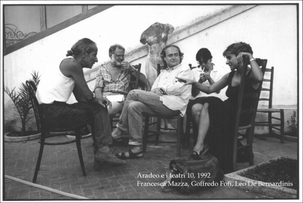 La fotografia in oggetto è stata scattata nel 1992 durante la rassegna annuale “Aradeo e i Teatri”, un appuntamento con il teatro sperimentale che la compagnia Koreja nata nel 1983 nel piccolo borgo salentino di Aradeo porta avanti sin dall'anno della sua fondazione.La fotografia cattura un momento di serena convivialità tra i protagonisti e gli attori che si esibirono, donando il proprio contributo artistico, in quell'edizione, giunta alla numero 10. Nella fotografia sono ritratti tra gli altri gli attori Francesca Mazza, Goffredo Fofi, Leo De Bernardinis. Elemento di prestigio dell'edizione di "Aradeo e i Teatri" del 1992 fu la partecipazione, per la prima volta, di Leo De Bernardinis, attore, drammaturgo e regista di teatro italiano, con lo spettacolo "L'uomo capovol...
