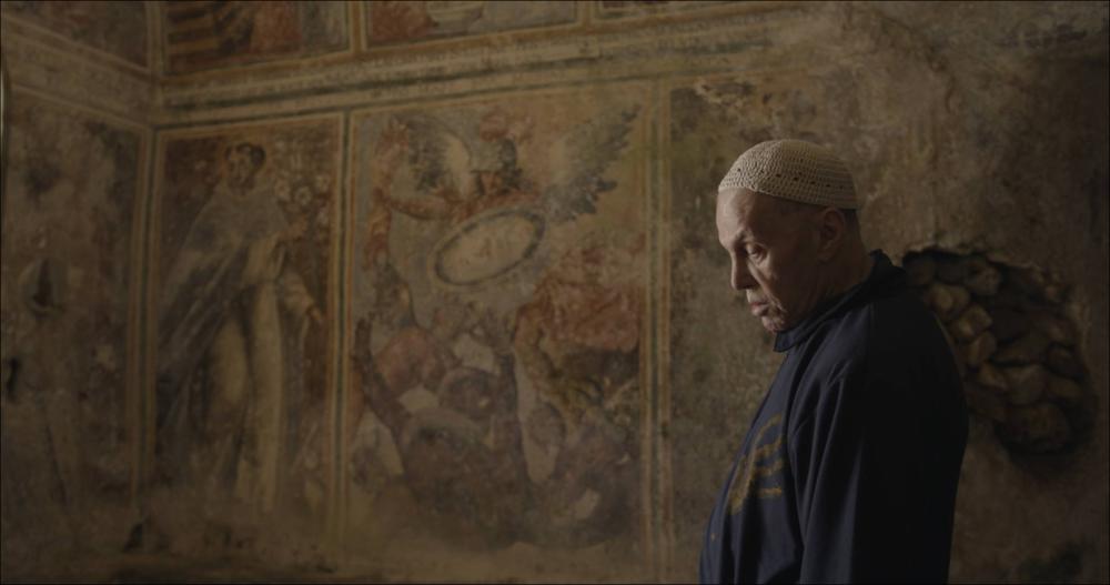 Lo scatto ritrae l’attore Luigi Mezzanotte in una scena tratta dal cortometraggio “Il Misuratore del Mondo”, opera della regista Irene Gianeselli, girato presso la Masseria Jesce di Altamura (2021). Con questo cortometraggio, la giovane regista pugliese Irene Gianeselli ci fa entrare in una nuova dimensione kafkiana, segnata dalle atmosfere mediterranee e rurali della masseria Jesce di Altamura che accoglie una struttura narrativa e interpretativa originale e nettamente ispirata al teatro. Il risultato è un’opera piena di spunti interessanti che è valso, alla Gianeselli e alla sua troupe, l’ingresso nella selezione ufficiale del David di Donatello 2022. Il monologo è liberamente tratto da “Il castello” di Franz Kafka e Luigi Mezzanotte n’è l’attore protagonista, raccogl...