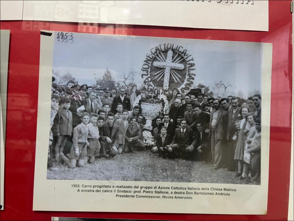 La digitalizzazione di questa foto storica del 1953 mostra uno dei tradizionali carri realizzati per la "Sfilata dei carri votivi".
La sfilata dei carri devozionali (o votivi) addobbati, che rievocano la leggenda del ritrovamento del crocifisso da parte dei contadini, è la principale celebrazione patronale della Festa del SS. Crocifisso di Auricarro a Palo del Colle e viene organizzata ancora oggi nel mese di maggio. I carri di Santa Croce sono strutture artistiche addobbate con forme di carta pesta, fiori e luminarie, rappresentanti temi religiosi, trainati da buoi, cavalli o trattori e realizzati a cura di associazioni, privati o scuole.
La Festa Patronale del SS. Crocifisso di Auricarro, istituita nel 1853, si celebra in due momenti diversi, il 3 Maggio e la terza se...