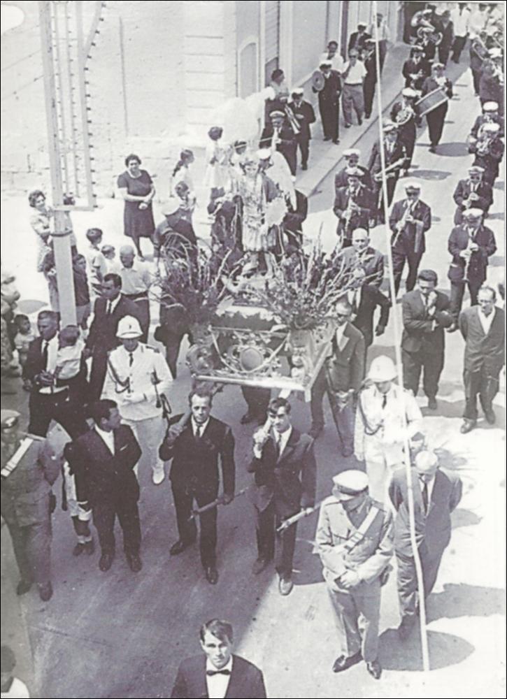 <div class="ql-editor">La fotografia, scattata dall’alto, cattura la processione di gala mattutina della Festa Patronale di Palese nel 1958. Si vede chiaramente la statua di San Michele Arcangelo trasportata dai portatori devoti, alcuni dei quali guardano verso la camera. La processione è accompagnata dalla banda che suona e dalle luminarie, creando un’immagine suggestiva che unisce devozione, musica e tradizione popolare, testimonianza dell’atmosfera solenne e gioiosa di quei festeggiamenti.<div>La Festa Patronale di Palese, borgo a nord di Bari, è dedicata a San Michele Arcangelo, celeste protettore della comunità. Si celebra ogni anno nei primi giorni di agosto e rappresenta il momento più alto e identitario della vita religiosa ...