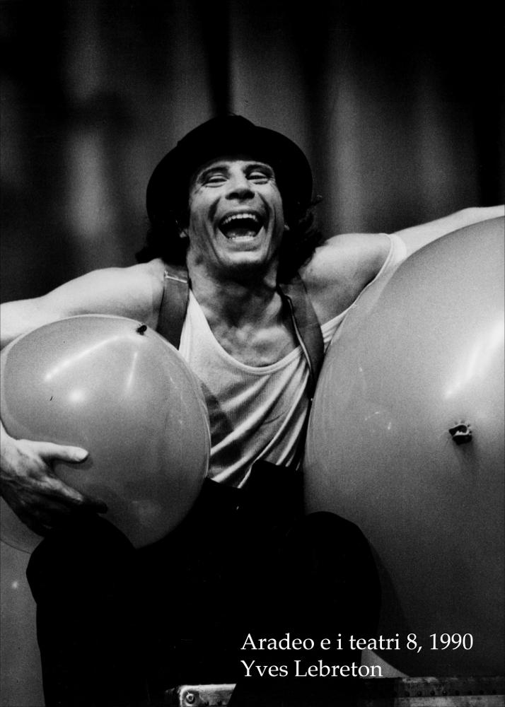 La fotografia in bianco e nero cattura un momento dello spettacolo "Eh?... O le avventure di Mr. Ballon" dell'autore e attore francese Yves Lebreton, rappresentato durante l'ottava edizione di "Aradeo e i Teatri", un appuntamento con il teatro sperimentale che la compagnia, nata nel 1983 nel piccolo borgo salentino di Aradeo, porta avanti sin dall'anno della sua fondazione. Esibitosi nell'agosto del 1990, nell'anno in cui il festival fu dedicato al teatro popolare, Yves Lebreton portò in scena uno spettacolo senza tempo concepito come un viaggio scenico nella comicità del nulla che fa divertire tutti. Con il suo stile inconfondibile Lebreton ha la capacità di comunicare immediatamente con il pubblico, anche grazie all'abilità di saper improvvisare. Comico surreale ed at...