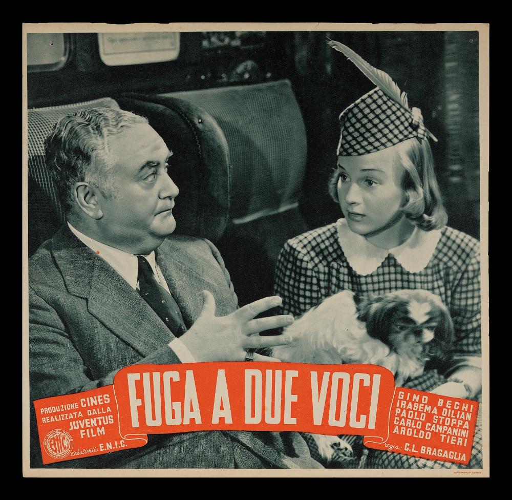 L'immagine riproduce uno dei soggetti delle fotobuste conservate presso la Mediateca Regionale Pugliese (vedi Note). Si tratta, nello specifico di uno dei soggetti della fotobusta del film in bianco e nero “Fuga a due voci” del 1943 per la regia di Carlo Ludovico Bragaglia. La fotografia di scena immortala un momento che verosimilmente si svolge in un treno. L’unico tocco di colore è rappresentato dal cartiglio arancione che racchiude i dati editoriali ed i credits del film....
