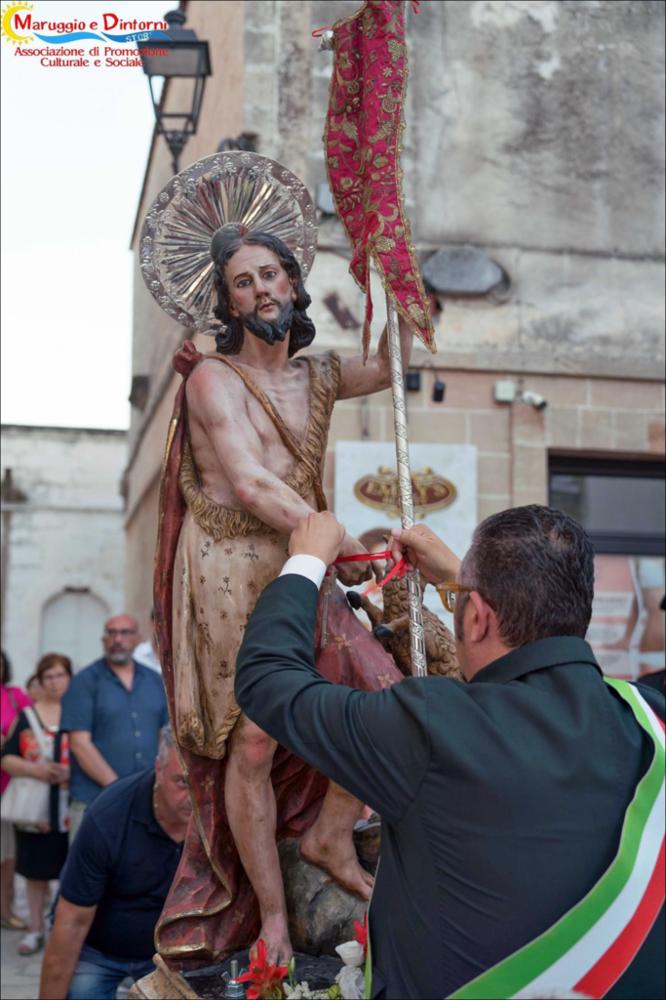 <div class="ql-editor"><div>La foto ritrae il momento simbolico della consegna delle chiavi della città alla statua di <strong>Giovanni Battista</strong> da parte del sindaco di <strong>Maruggio</strong>. Il gesto rappresenta uno dei passaggi più significativi della festa patronale: l’autorità civile affida idealmente la comunità alla protezione del santo patrono. Attorno al simulacro si raccolgono fedeli, autorità e membri del comitato festa, in un clima di devozione e partecipazione che sottolinea il forte legame tra la tradizione religiosa e la vita della comunità.</div><div><br></div><div>La festa patronale di <strong>Maruggio</strong> è dedicata a <strong>Giovanni Battista</strong> e, dal 1962, anche a <strong>Cristoforo</st...