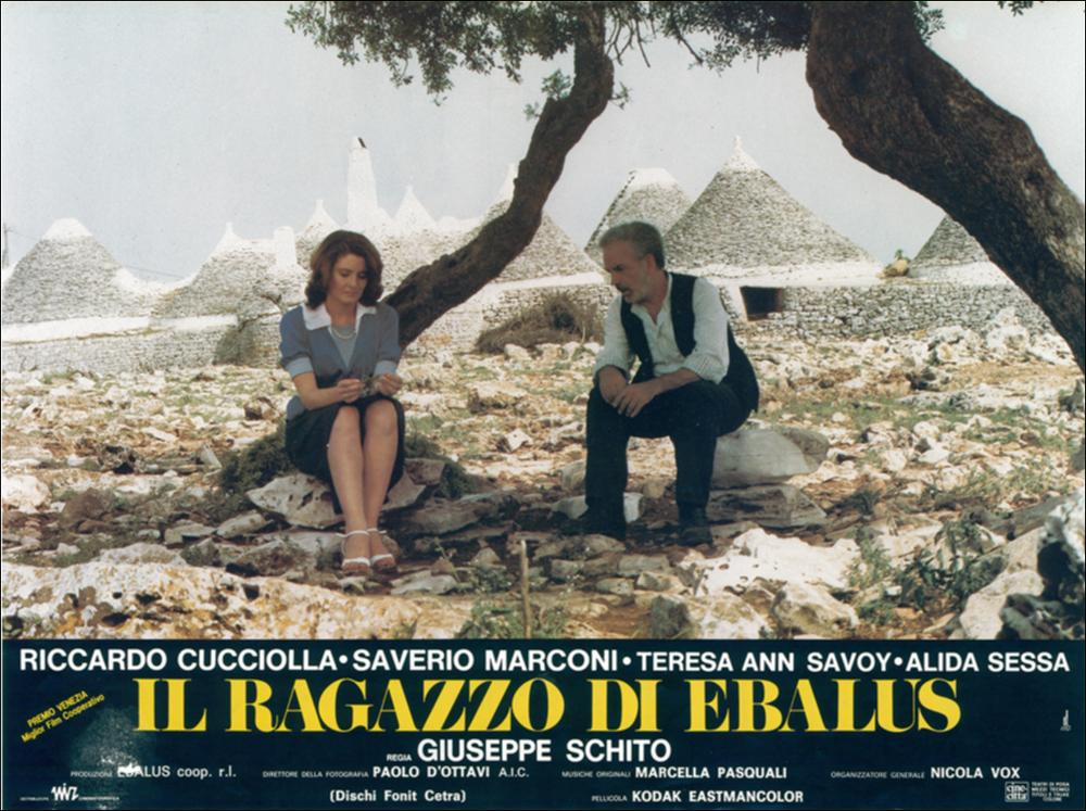 L'immagine digitale in oggetto è la scansione della fotobusta del film “Il ragazzo di Ebalus”, elaborata in occasione della mostra "Riccardo Cucciolla - Ritratto d'Attore" organizzata nel 2012 dall'Associazione culturale “Attraverso lo Spettacolo”, dall'Assessorato al Mediterraneo, Cultura e Turismo della Regione Puglia e dal Servizio Biblioteca e Comunicazione Istituzionale del Consiglio Regionale della Puglia. L'opera grafica, attraverso una delle immagini più belle e rappresentative della Puglia, svela quello che fu il set cinematografico de Il ragazzo di Ebalus. Così mentre in primo piano i due attori sono intenti a discutere sulla sorte del giovane terrorista, alle loro spalle gli inconfondibili trulli incorniciano la scena. Film del 1984 diretto dal regista puglie...