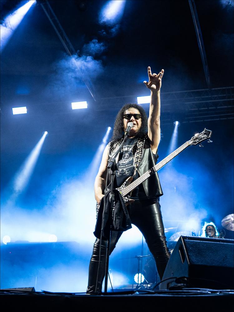<div>Lo scatto racconta un momento del concerto di Gene Simmons, protagonista della serata del 16 agosto 2024 del Cinzella Festival, alla Rotonda del Lungomare di Taranto. Considerato una delle icone del rock mondiale, Simmons ha rappresentato l’evento di punta dell’edizione. Nato come Chaim Witz, ha iniziato la sua carriera come bassista in band locali, fino all’incontro con Paul Stanley, con cui ha fondato i Wicked Lester, sviluppando l’idea di trasformare il concerto in uno spettacolo teatrale con costumi e trucco scenico. Con l’ingresso di Peter Criss e Ace Frehley nasce la leggendaria band KISS.</div><div>Parallelamente alla musica, Simmons si è affermato come attore e abile imprenditore, trasformando i KISS in un vero e proprio b...