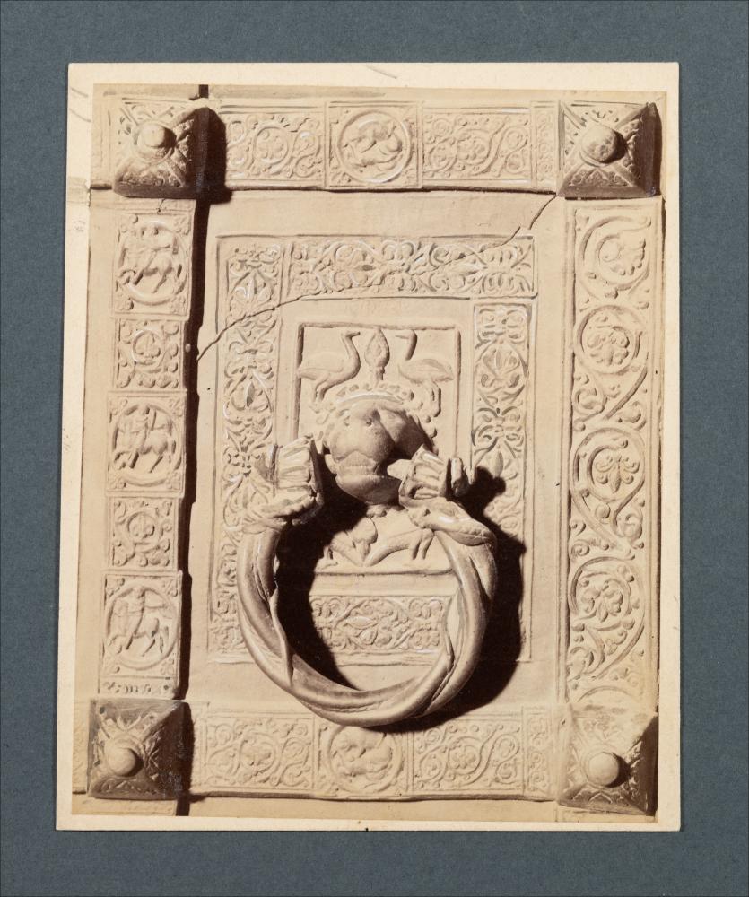 <div class="ql-editor"><div>Documentazione fotografica di una formella decorativa della porta bronzea della Cattedrale di Trani. La formella, risalente al XII secolo, è opera di Barisano da Trani, con <span>testa leonina reggi-batacchio tra motivi vegetali, animali e antropomorfi </span></div><div>L'immagine digitale fa parte della raccolta fotografica di Giuseppe Ceci (1863-1938), studioso delle arti figurative dell’Italia meridionale e tra i promotori delle Società di Storia Patria di Napoli e della Puglia. Tale raccolta si inserisce nel vivace clima culturale dell’Italia postunitaria, caratterizzato dal progressivo consolidarsi di una «coscienza nazionale» alimentata anche dal confronto e dal dialogo con le realtà storiche e cultu...