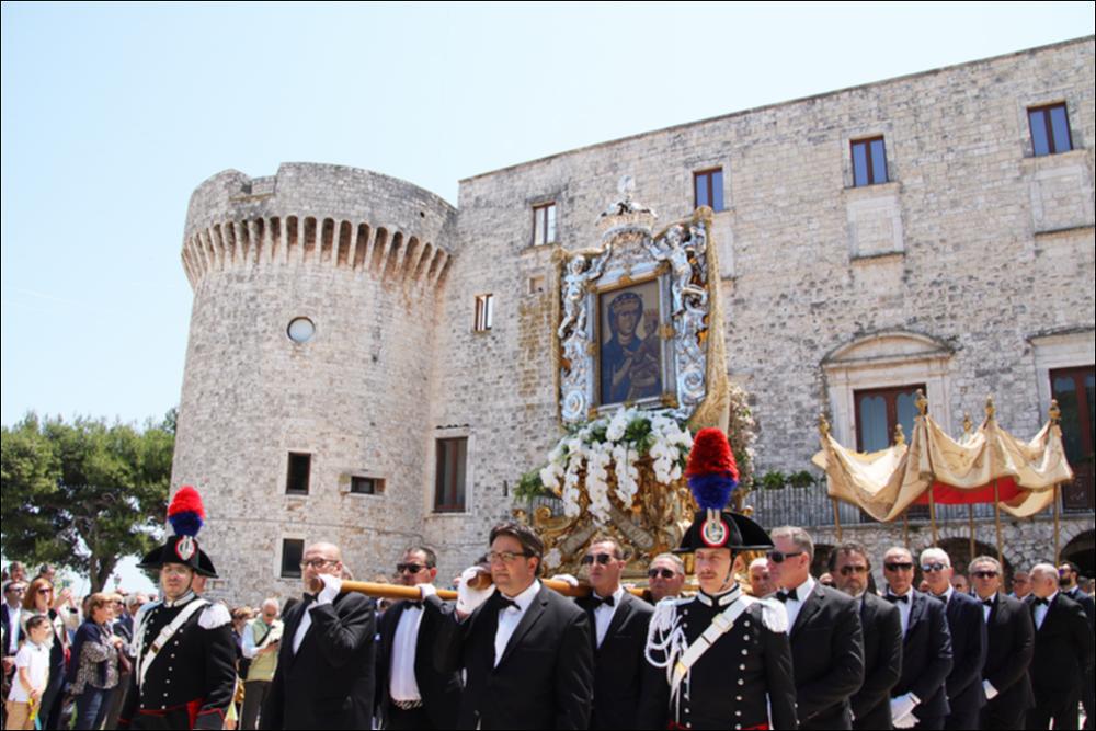 <div class="ql-editor"><div>La foto ritrae la sacra pala della Madonna della Fonte, con la preziosa cornice argentea, portata in spalla durante la processione davanti al maestoso <strong>Castello di Conversano</strong>. Particolarmente suggestiva è la <strong>Processione di Gala</strong> della <strong>Madonna della Fonte</strong>, che segue il Solenne Pontificale presieduto dal Vescovo e durante la quale vengono benedetti città, campagna, mare e Seminario. Al corteo partecipano confraternite, associazioni e autorità civili e militari, mentre il sabato mattina i bambini delle scuole omaggiano la Protettrice con fiori e disegni, esposti poi nella Villa Garibaldi.</div><div><br></div><div>La Festa della Madonna della Fonte di Conversano, celebrata dalla <str...