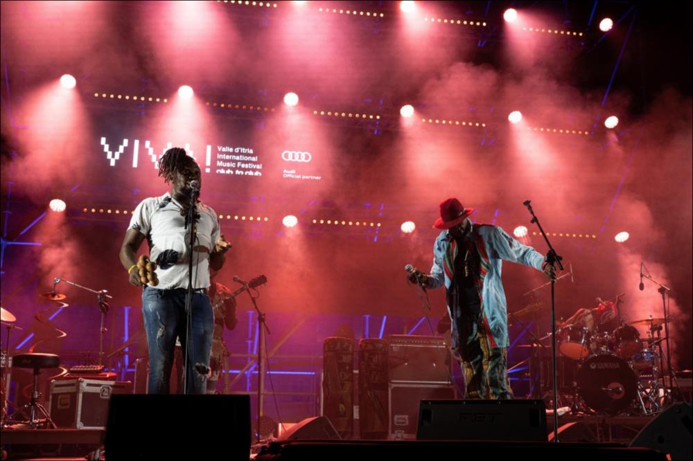 In foto l’esibizione degli Jupiter & Okwess presso la Masseria Aprile a Locorotondo in occasione del VIVA! Festival 2021 nella serata del 7 agosto.
La musica degli Jupiter & Okwess, intrisa di risonanze che richiamano l’eredità musicale del Congo, sorprende per la sua incredibile modernità e per la combinazione di influenze di cui si è preziosamente impregnata la loro musica durante i numerosi viaggi in tutto il mondo. Importante anche il contributo di artisti eclettici come Damon Albarn, che li ha ingaggiati nel tour Africa Express, Warren Ellis e Robert del Naja....